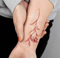 a woman's hand with a flower tattoo on it