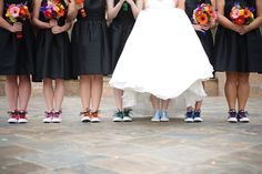 a group of women standing next to each other in front of a man holding a bouquet