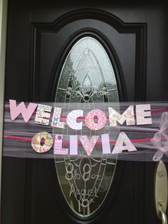 a welcome sign hanging on the front door of a house that is decorated with donuts