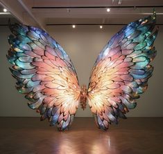 a large angel wings sculpture on display in an art gallery