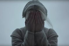 a woman covering her face with both hands