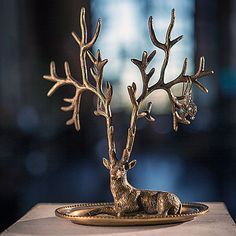 a deer figurine sitting on top of a gold plate