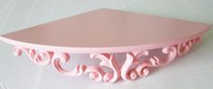 a pink shelf sitting on top of a white table