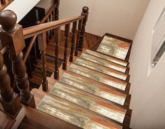 the stair treads in this house are made of wood and have decorative rugs on them