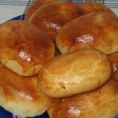 a blue plate topped with rolls on top of a table