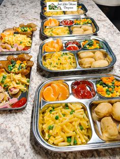 several trays of food are lined up on a table with an advertisement in the background