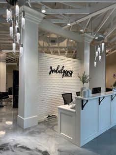 the interior of a modern office with white brick walls and black lettering on the wall