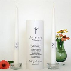 two candles with names on them next to a vase