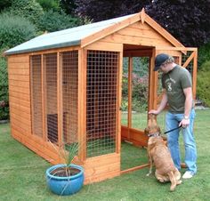 a man standing next to a dog in front of a chicken coop