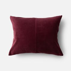 a dark red pillow on a white background