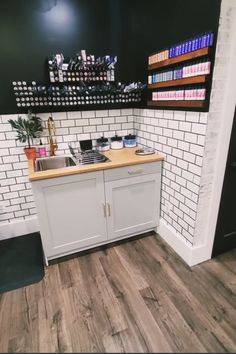 a kitchen with white brick walls and wood flooring in the center, along with shelving on the wall