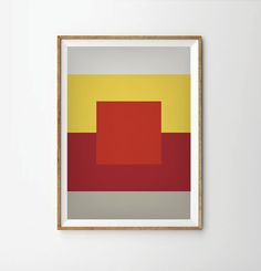 an abstract painting with red, yellow and grey squares in a wooden frame on the wall