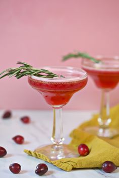 two glasses filled with cranberry and rosemary cocktails