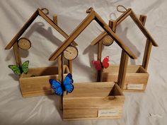 three wooden birdhouses with butterflies on them