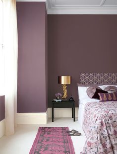 a bedroom with purple walls and white carpet