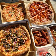 four pizzas in boxes with different toppings on them