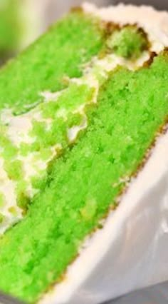 a green cake with white frosting on top