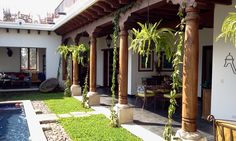 an outdoor patio with grass and plants next to a swimming pool