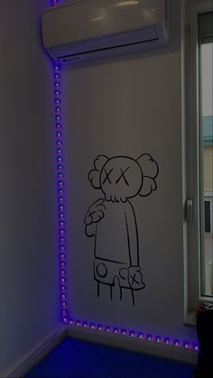 a room with a drawing on the wall next to a window and a blue light