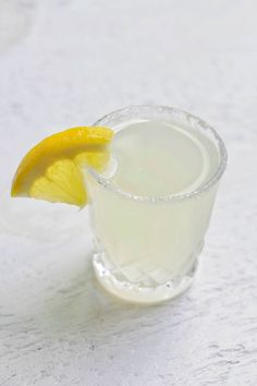 a drink with a lemon wedge on the rim