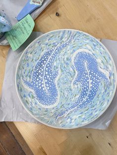 a blue and white bowl sitting on top of a wooden table