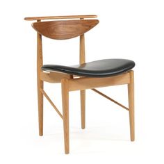 a wooden chair with black leather seat pad on it's back end and armrests