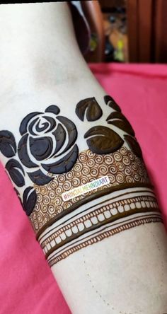 a woman's arm covered in hendik with flowers and leaves on it