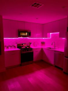 the kitchen is lit up with pink lighting