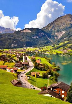 a scenic lake surrounded by mountains and houses