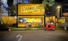 a scooter parked in front of a restaurant with people sitting at the table