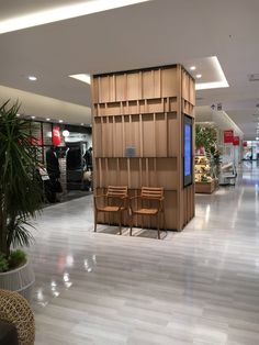 an empty shopping mall with chairs and tables in front of the display case, along with other items