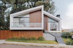 a modern house with wooden siding and glass windows