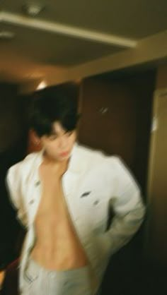 a blurry photo of a shirtless man standing in a room with his hands on his hips