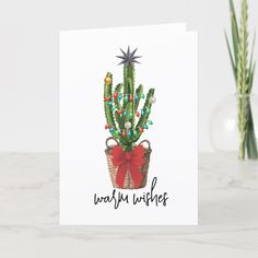 a christmas card with a cactus in a basket and the words merry wishes on it