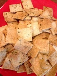 a red plate topped with crackers on top of a wooden table