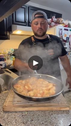 a man standing in front of a frying pan filled with food