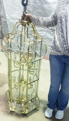 a woman standing next to a large metal cage