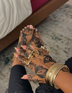 a woman's hands with tattoos and bracelets