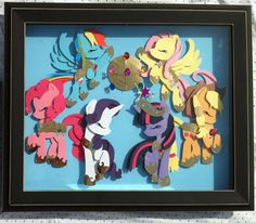 a shadow box frame with cut outs of different cartoon characters in the shape of ponies