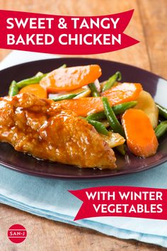 sweet and tangy baked chicken with winter vegetables on a black plate next to a blue napkin