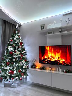 a decorated christmas tree in front of a fireplace