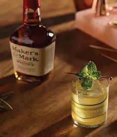 a bottle of miller's mark next to a glass with a cucumber garnish