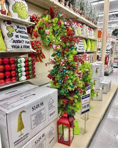 a christmas tree in the middle of a store aisle with other items for sale behind it