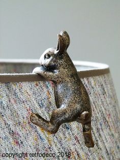 a close up of a lamp shade with a small animal on it's side