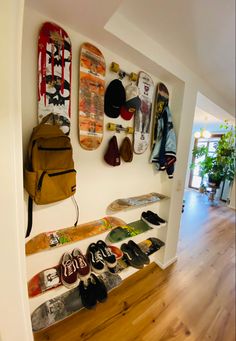 there are many skateboards on the wall and in the hallway, along with shoes