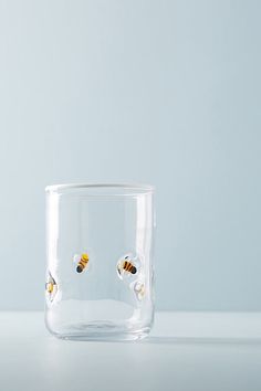 a clear glass with gold bee studs on the inside and bottom, sitting on a white surface