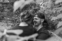 black and white photograph of two people sitting on a park bench looking at each other