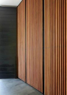 an empty room with wooden slats on the wall and flooring in front of it