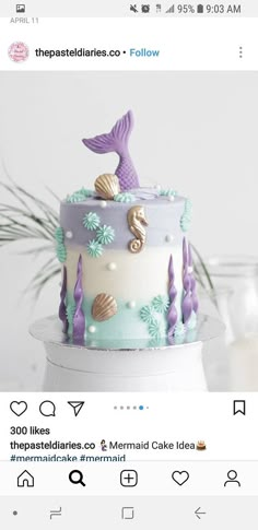 the cake is decorated with mermaids and seashells on it's sides