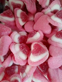 pink and white heart shaped candies are on a plate, ready to be eaten